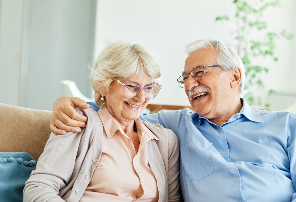 Smiling senior couple sitting together on a sofa
